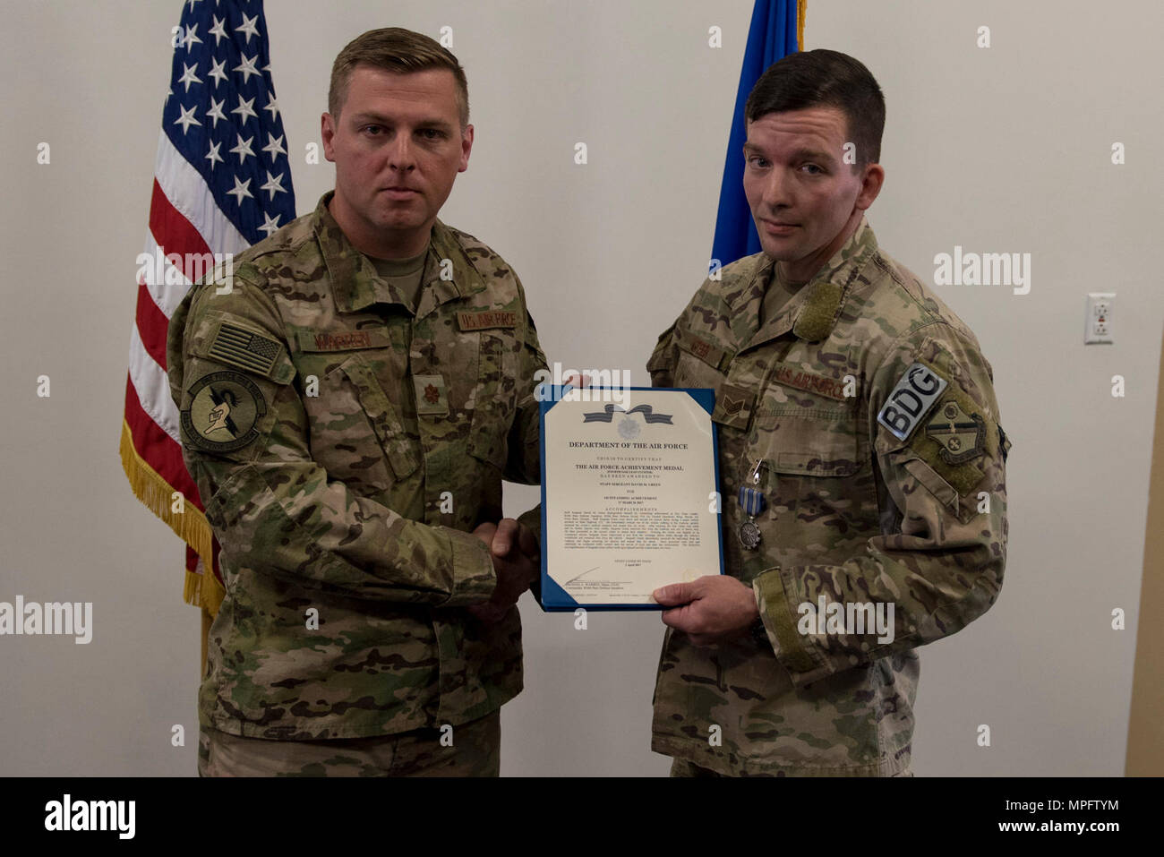 Maj. Michael Warren, 824th Base Defense Squadron commander, awards Staff Sgt. David Green, 824th BDS fireteam leader, with an achievement medal, April 10, 2017, at Moody Air Force Base, Ga. Green received the medal for his act of heroism when he helped a trapped victim during an off-base vehicle incident. Stock Photo