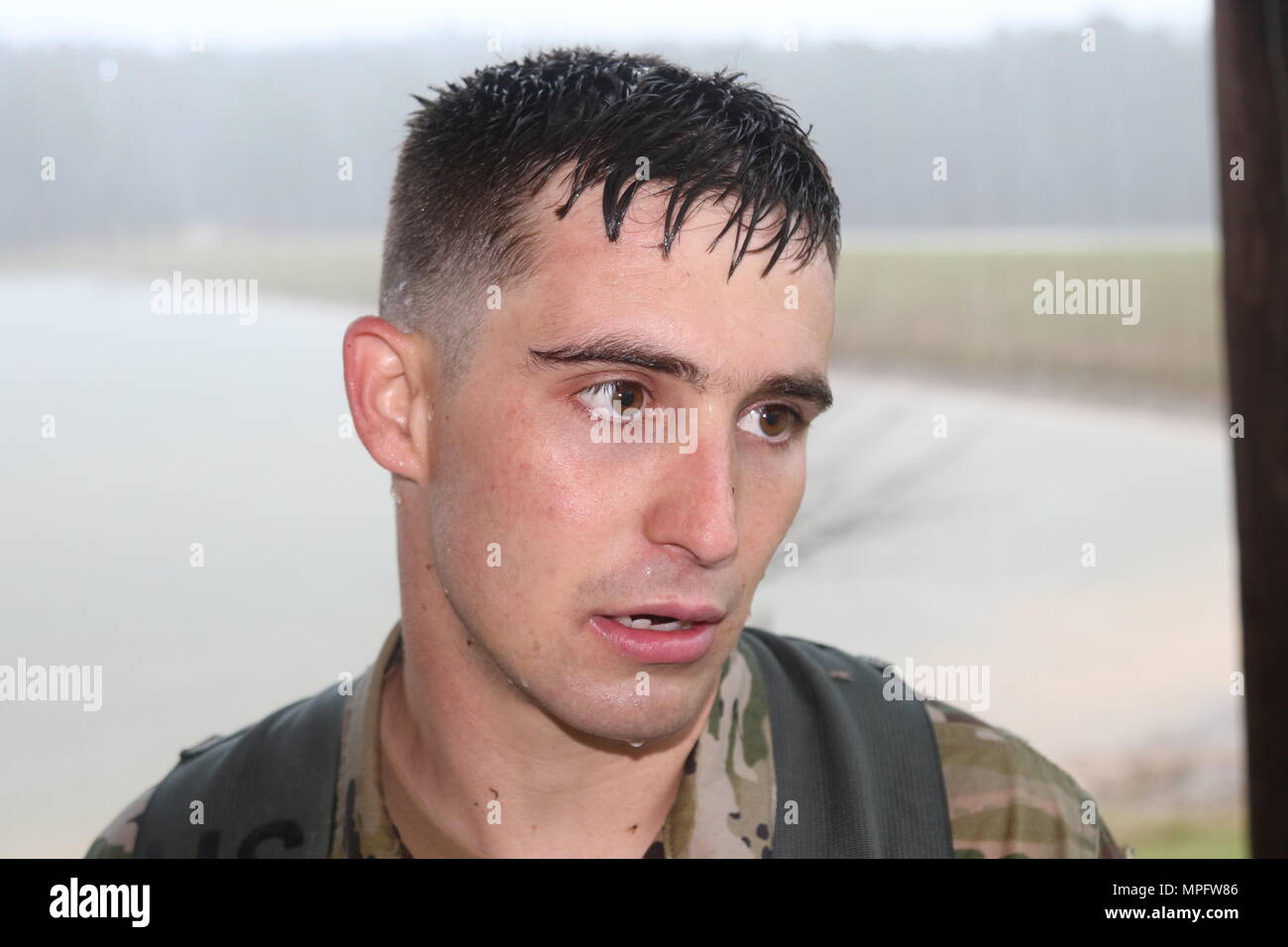 Sgt. Austin Eubanks, 287th Engineer Company based in Lucedale, Miss., recovers after conducting a land navigation course in a torrential downpour during the Mississippi National Guard’s 2017 Best Warrior Competition at Camp McCain near Elliott, Miss., March 7, 2017. (Mississippi National Guard photo by Staff Sgt. Scott Tynes, 102d Public Affairs Detachment) Stock Photo