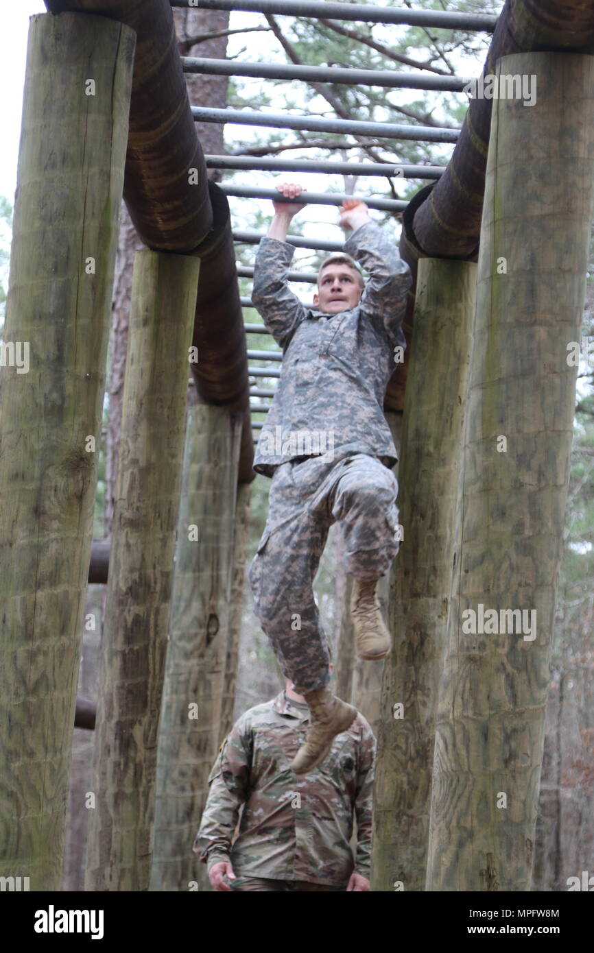 Cpl. Cody Pellegrin, 287th Engineer Company based in Lucedale, Miss., navigates the monkey bars on the confidence course during the Mississippi National Guard’s 2017 Best Warrior Competition at Camp McCain near Elliott, Miss., March 9, 2017. (Mississippi National Guard photo by Staff Sgt. Scott Tynes, 102d Public Affairs Detachment) Stock Photo
