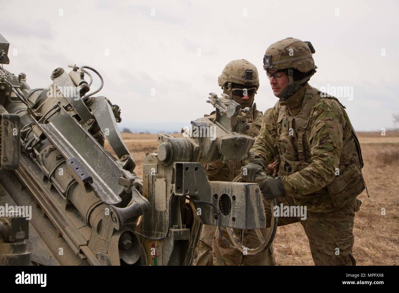 Sgt. David Beale (front), assistant gunner, and Spc. Vincent Ventarola, both members of the gun crew for 1st Section, 1st Platoon, Cobra Battery, Field Artillery Squadron, 2d Cavalry Regiment, U.S. Army, conduct a fire mission with their M777A2 Howitzer during a March 8, 2017 in the Grafenwoehr Training Area, Germany. The Squadron participated in Dynamic Front II March 6-9, 2017. The exercise enabled the U.S., Germany and Czech Republic to synchronize their artillery capabilities. (U.S. Army photo by Staff Sgt. Jennifer Bunn) Stock Photo
