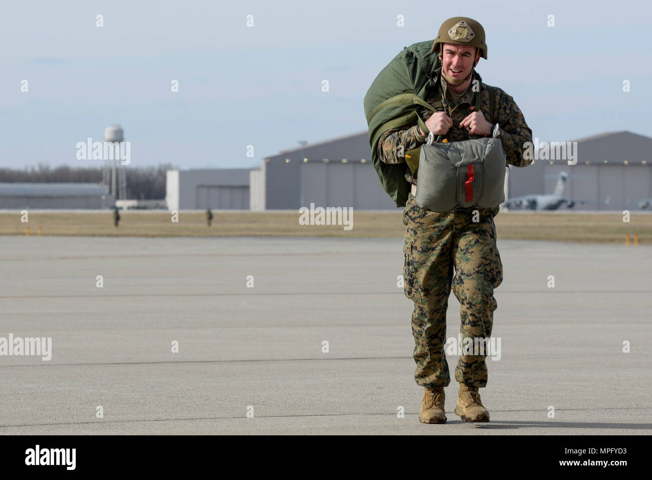 Marine Capt. Richard Spicer, a firepower control team leader with the 4th Air Naval Gunfire Liaison Company, West Palm Beach, Fla., returns from the drop zone after a successful jump at Wright-Patterson Air Force Base, Ohio, March 11, 2017. Members of the 88th Operations Support Squadron, 88th Security Forces Squadron, 788th Civil Engineer Squadron, and 88th Medical Operations Squadron provided support to the paratroop operations. (U.S. Air Force photo by Wesley Farnsworth / Released) Stock Photo