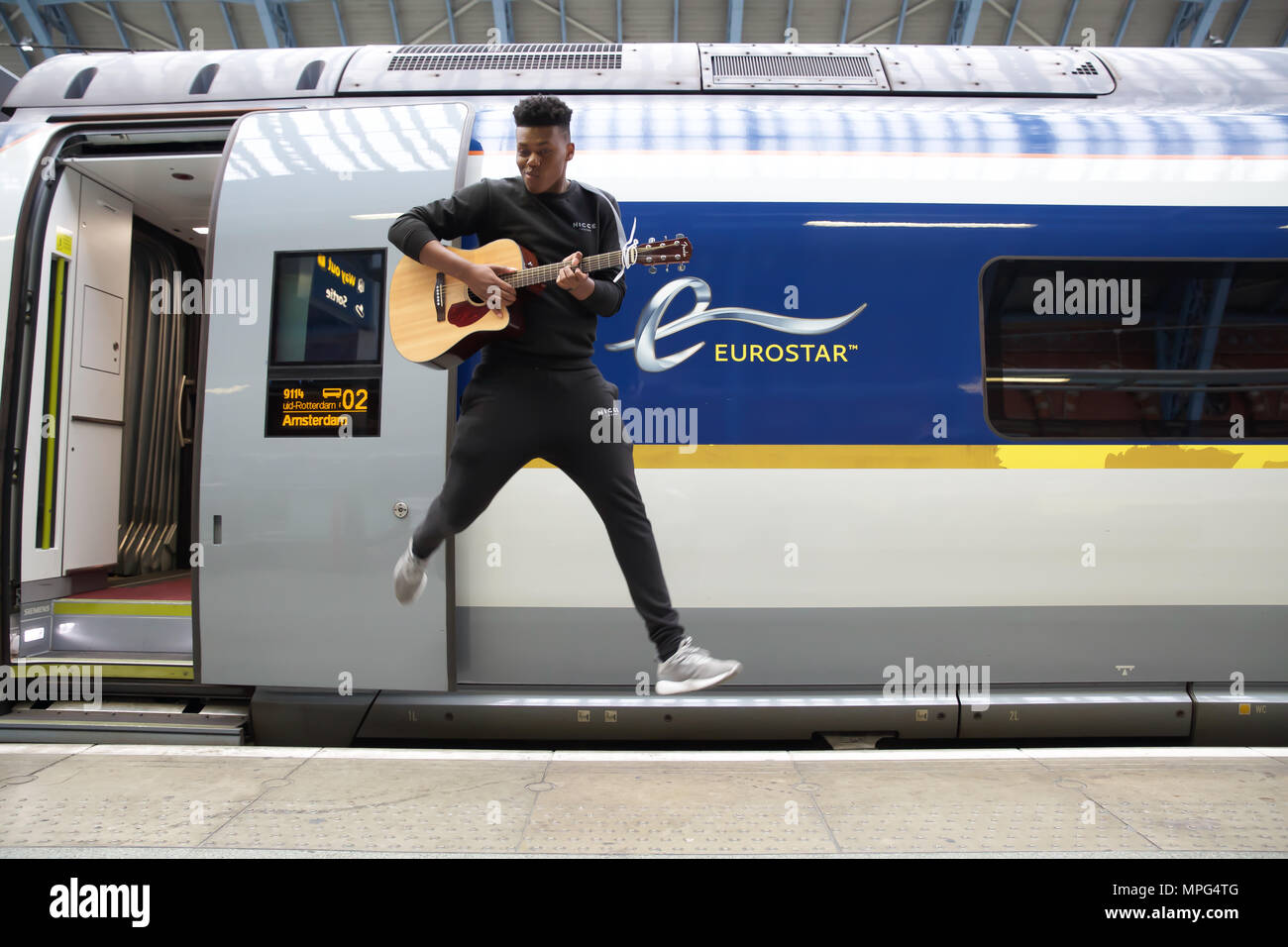 St Pancras, UK. 23rd May 2018. Ky Lewis, Winner of Gigs Eurostar prize jumps for joy before he boards the train to Amsterdam. He set off on a whirlwind busking tour of Amsterdam. He will serenade passengers on the train as they travel under the Channel and complete the day busking in Amsterdam.Credit Keith Larby/Alamy Live News Stock Photo