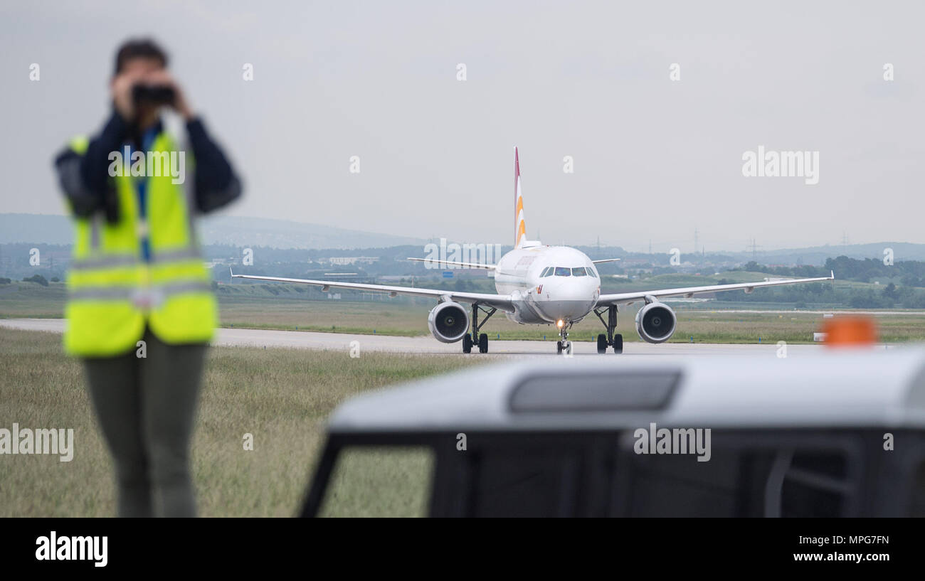 23 May 2018, Stuttgart, Germany: Bird vermin Anna Kopp looks through binoculars and in the backrground a plane is driving. According to the German Committee for the Prevention of Bird Strikes in Air Traffic (DAVVL), up to 2,100 so-called bird strikes are registered per year in the German airspace. Many airports are trying to scare away the birds. Photo: Sebastian Gollnow/dpa Stock Photo