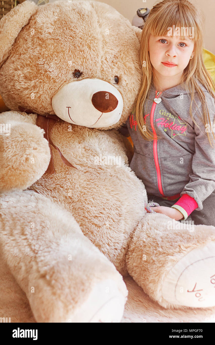 girl hugging a big teddy bear