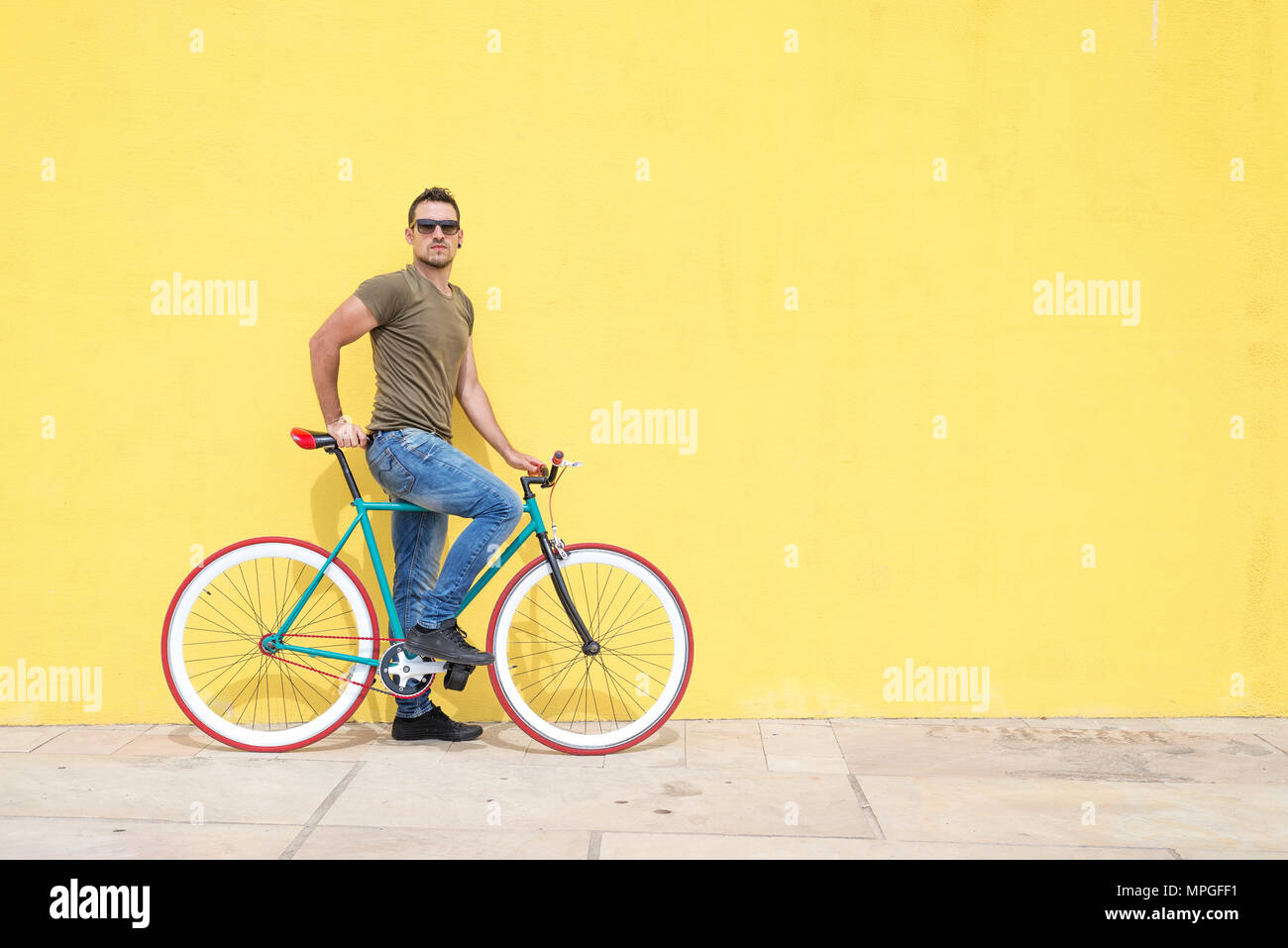 Man posing with his fixed gear bicycle wearing sunglasses Stock Photo