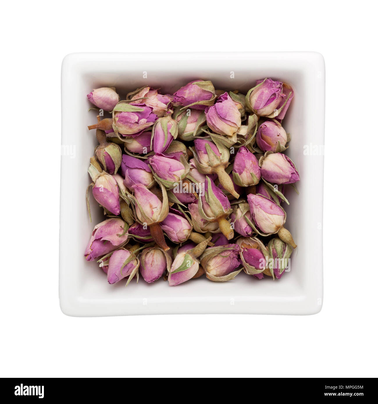 Dried french rosebuds in a square bowl isolated on white background Stock Photo