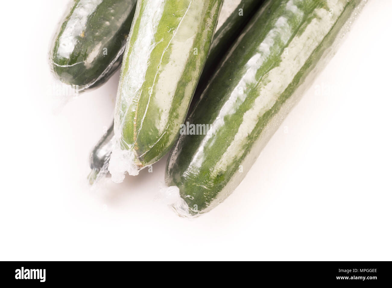 Bunch of cucumber wrapped in plastic films, isolated on white background Stock Photo