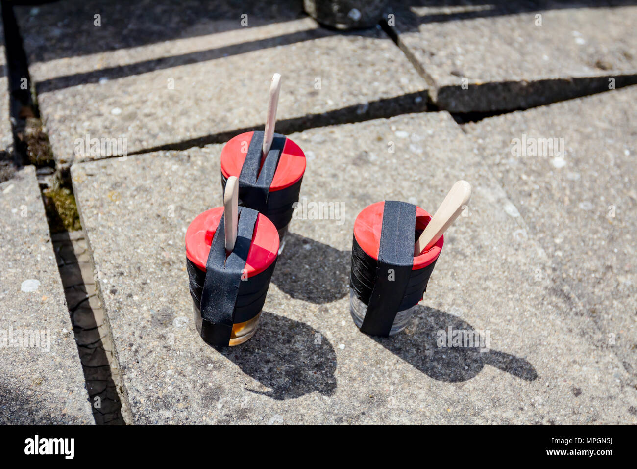 Epoxy glue ingredients, resin and hardener in small cups with wooden