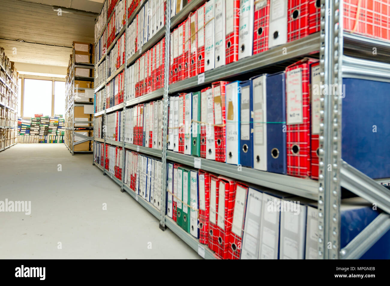 Stacks of files and paperwork placed in bookshelves with folders and