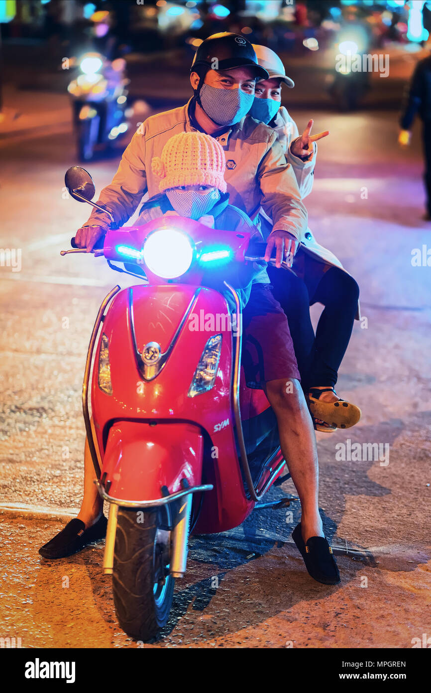 Hoi An, Vietnam - February 16, 2016: Family on Motorcycle in the street of old city of Hoi An, Vietnam. Late in the evening Stock Photo