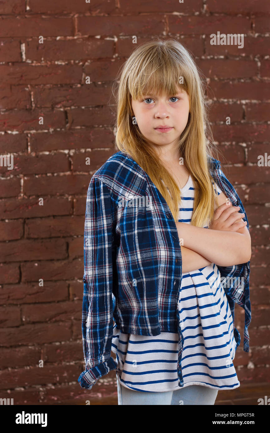Girl 6 years old in jeans and shirt is thrown against the wall. half