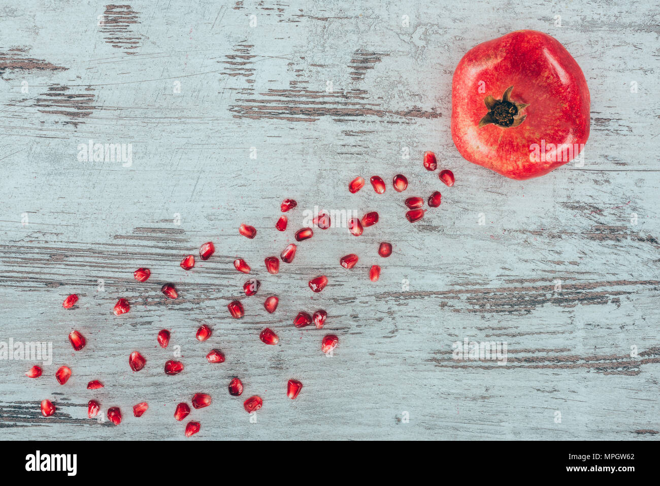 Pomegranate with seeds on wooden surface Stock Photo