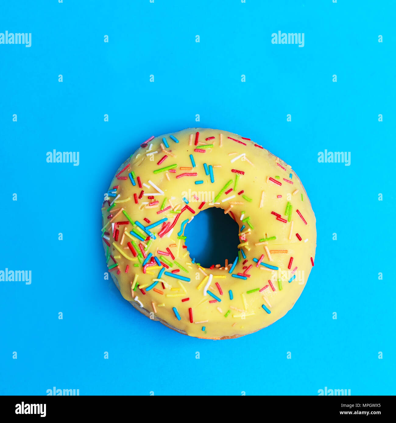 Download Bright Yellow Round Donuts With Colorful Sprinkles On A Blue Background Stock Photo Alamy PSD Mockup Templates