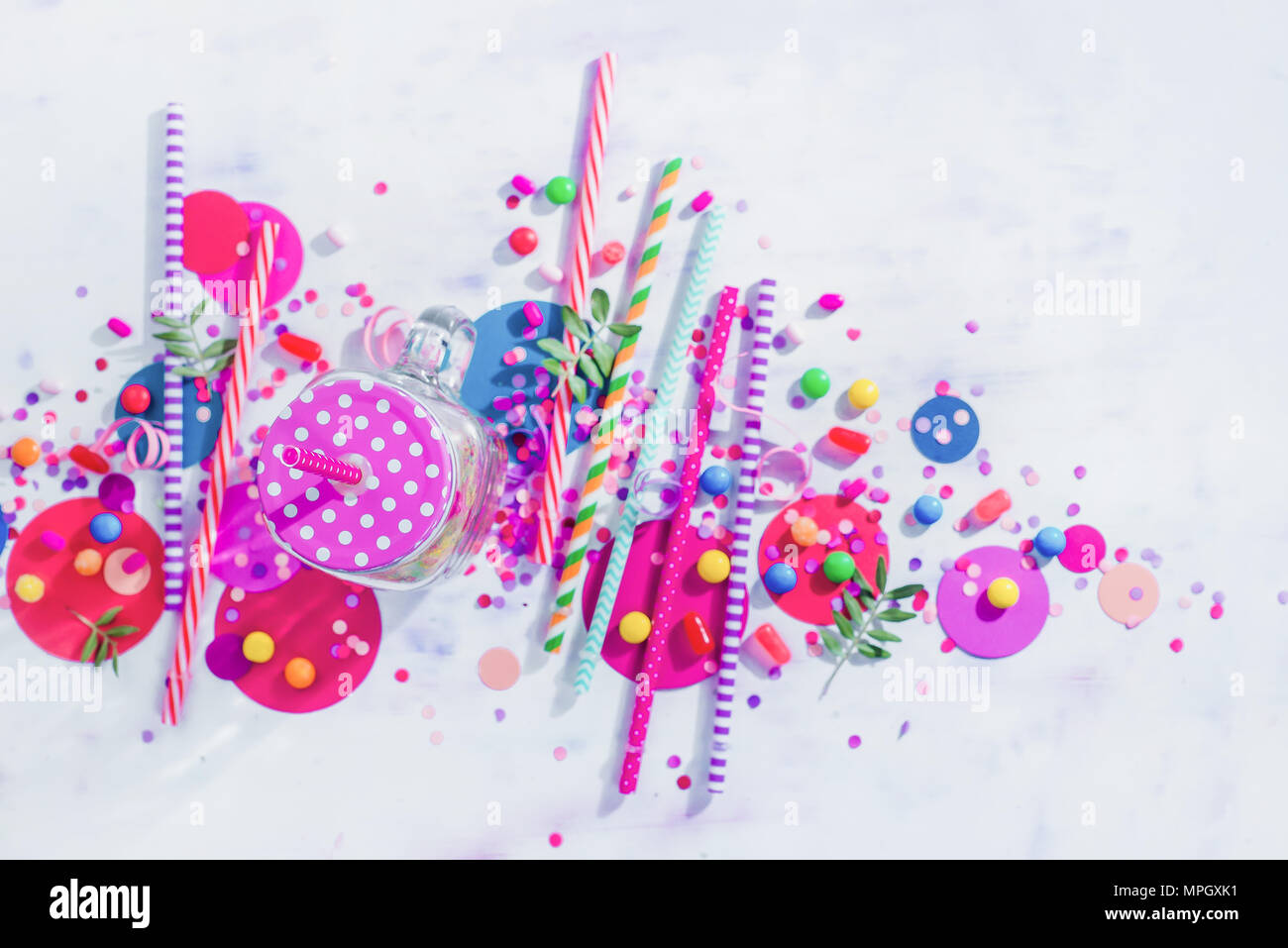 Holiday frame or background with colorful straws, confetti and hard candy. Birthday or party greeting card flat lay with copy space. Stock Photo