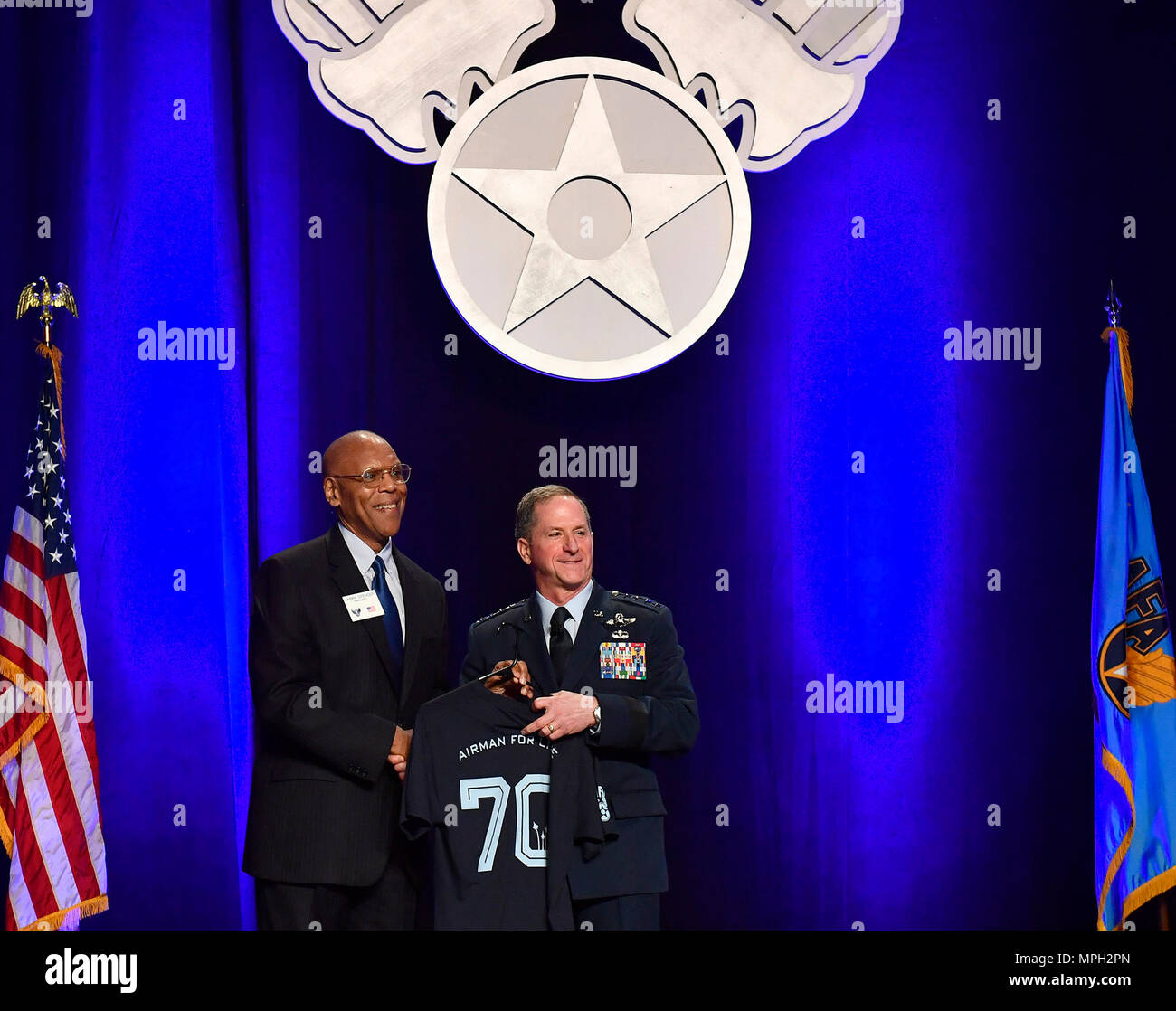 Air Force Chief of Staff Gen. David L. Goldfein receives an 'Airman for Life' T-shrt from AFA president Gen. (ret.) Larry O. Spencer, following his 'Air Force Update,' at the Air Force Association Air Warfare Symposium March 2, 2016, in Orlando, Fla.  (U.S. Air Force photo/Scott M. Ash) Stock Photo