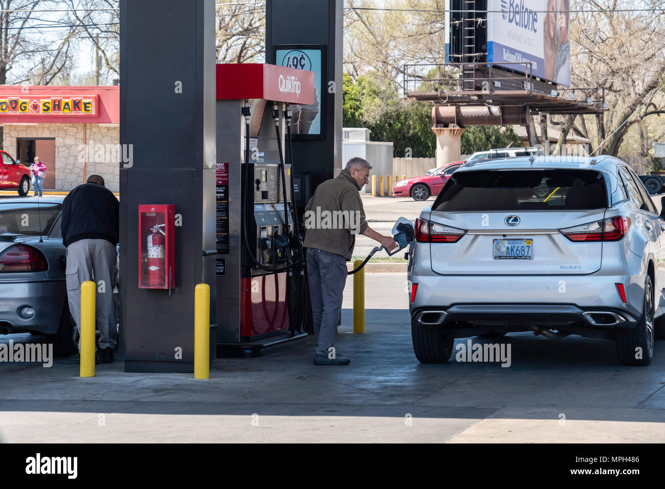 Two men fill their automobile gas tanks at QuickTrip in Wichita, Kansas, USA. Stock Photo