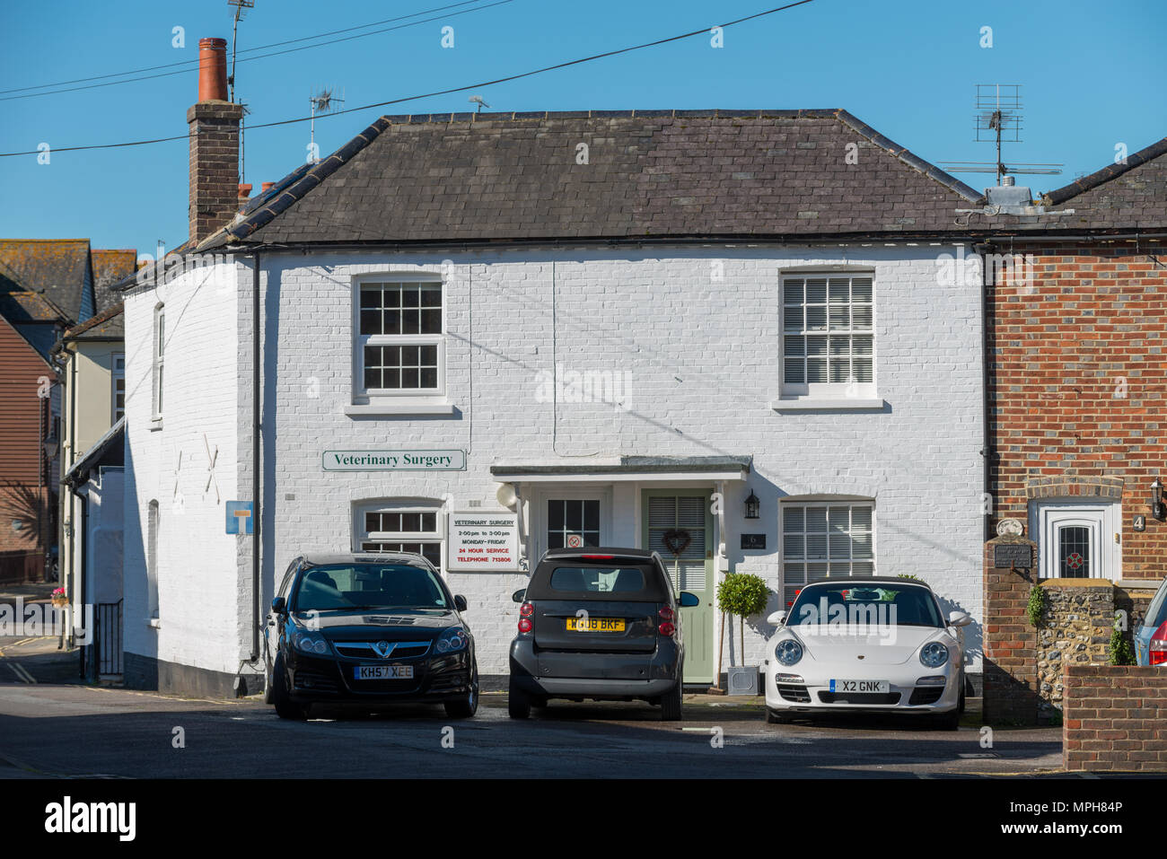 Cars Parked In Front Of A White Painted Cottage At Arundel In West