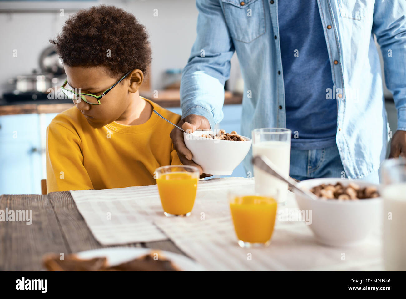 Curly-haired pre-teen boy not wanting to eat cereals Stock Photo