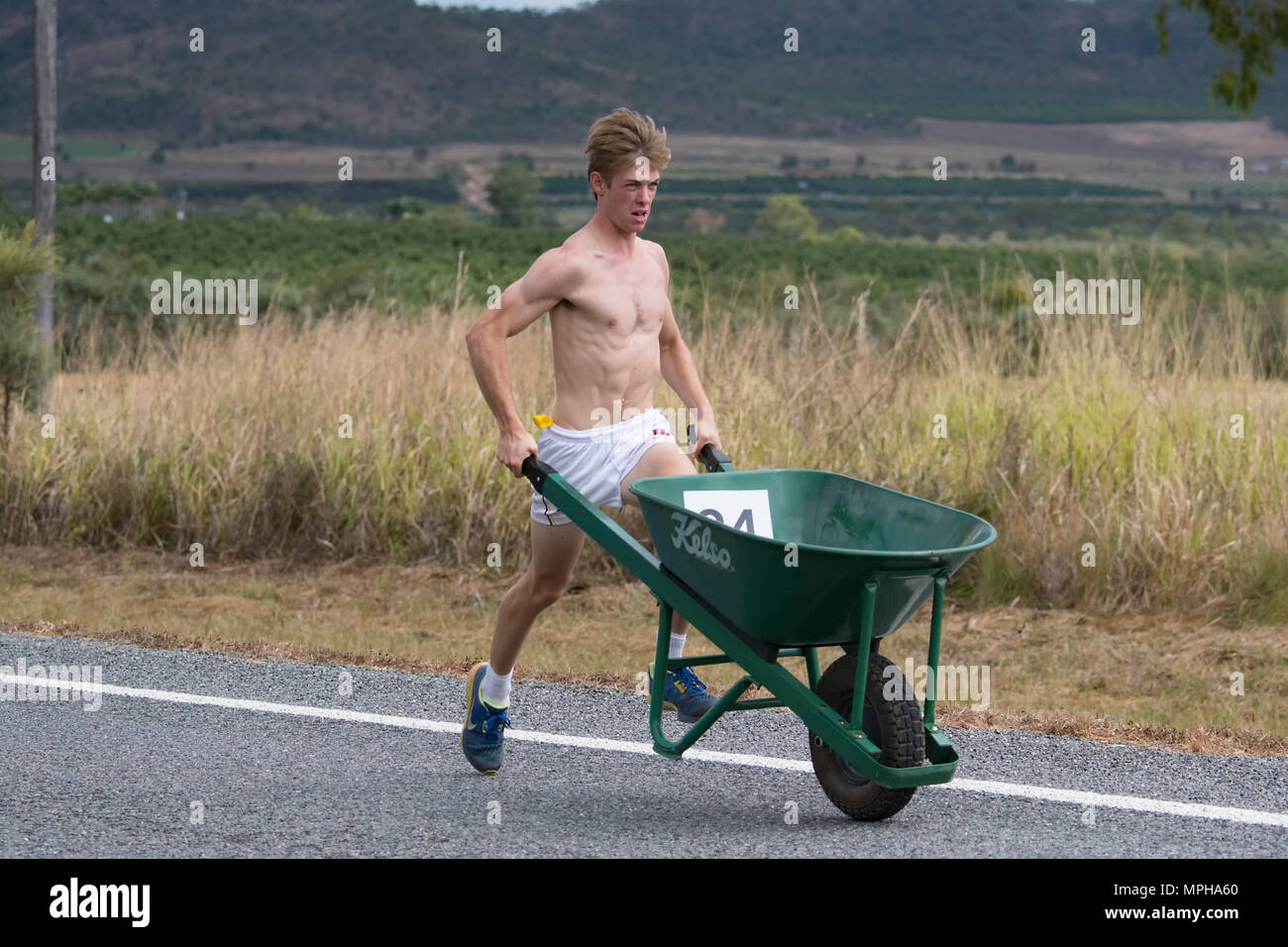 Male participant in The Great Wheelbarrow Race from Chillagoe to Mareeba, a fundraising event in Far North Queensland, FNQ, QLD, Australia Stock Photo