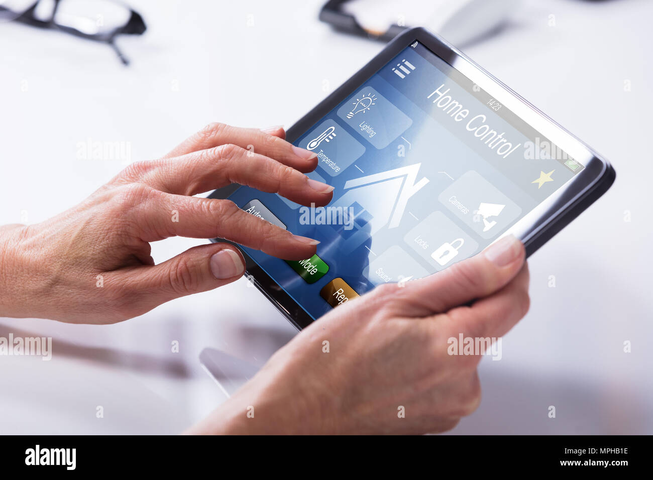 Close-up Of A Person's Hand Using Home Control System On Digital Tablet Stock Photo
