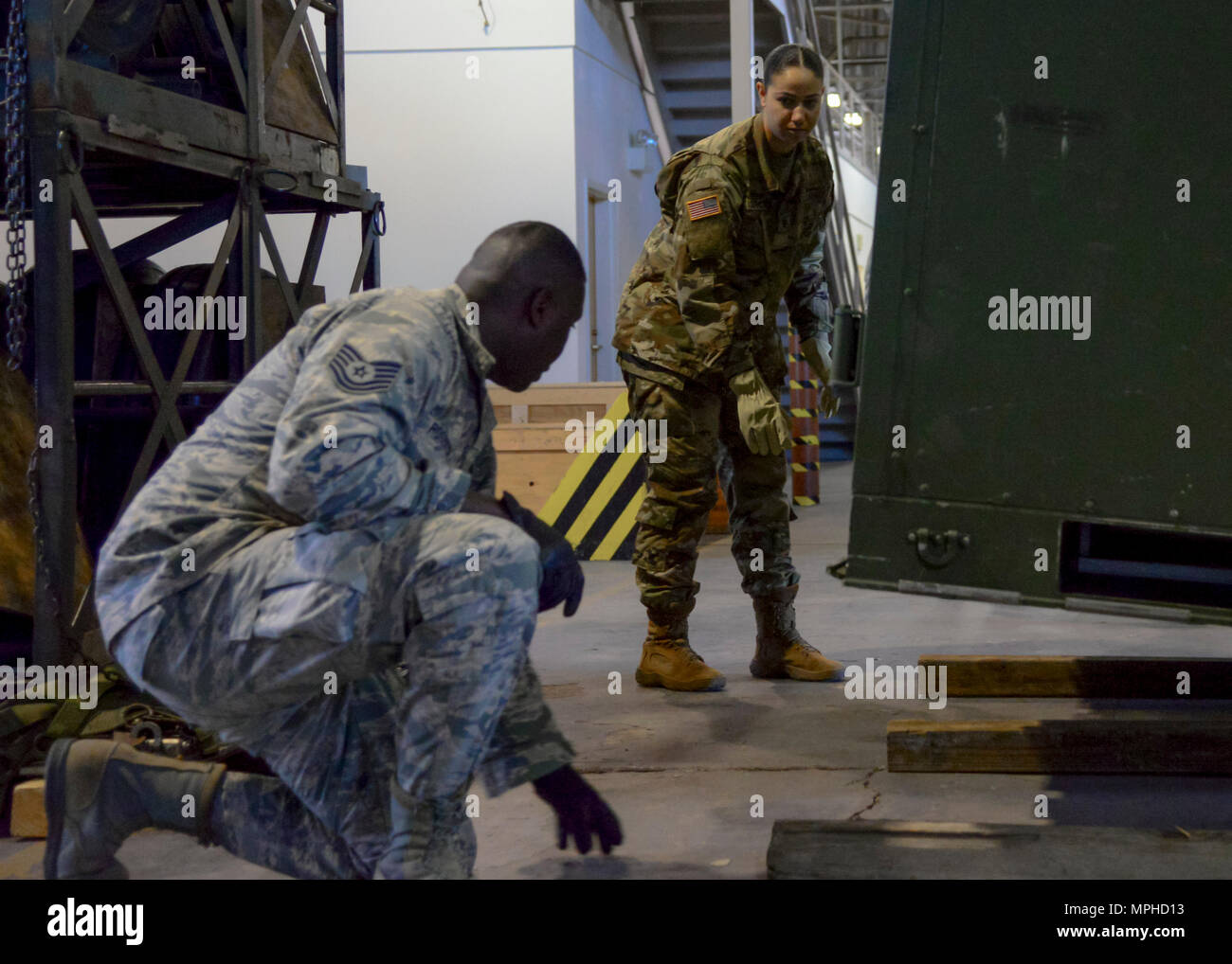 U.S. Air Force Tech. Sgt. Jeremy Roberts, 733rd Logistic Readiness Squadron, readiness spares package NCO in charge, shows U.S. Army Spc. Jena Garcia, 119th Inland Cargo Transfer Company, 11th Transportation Battalion, 7th Transportation Brigade (Expeditionary), motor pool clerk, how to lay a support platform for a supply pod at Joint Base Langley- Eustis, March 2, 2017. Garcia and other Soldiers spent a week training with 733rd LRS Airmen to learn how the Air Force manages its logistics procedures. (U.S. Air Force photo by 1st Lt. Mahalia Frost) Stock Photo