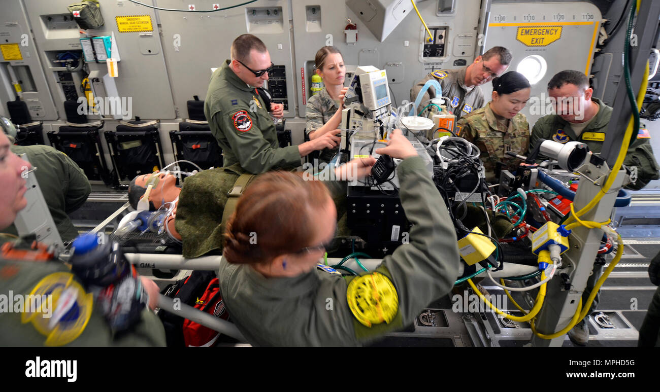 Air Force and Army medics stabilize a simulated patient connected to an extracorporeal membrane oxygenation machine (ECMO) upon boarding a C-17 Globemaster III for transport from Patrick Air Force Base, Florida, March 4, 2017 as part of the 5th annual MEDBEACH joint medical response exercise. ECMO is a treatment that uses a pump to circulate blood through an artificial lung back into the bloodstream of a patient. (U.S. Air Force photo/Tech. Sgt. Lindsey Maurice) Stock Photo
