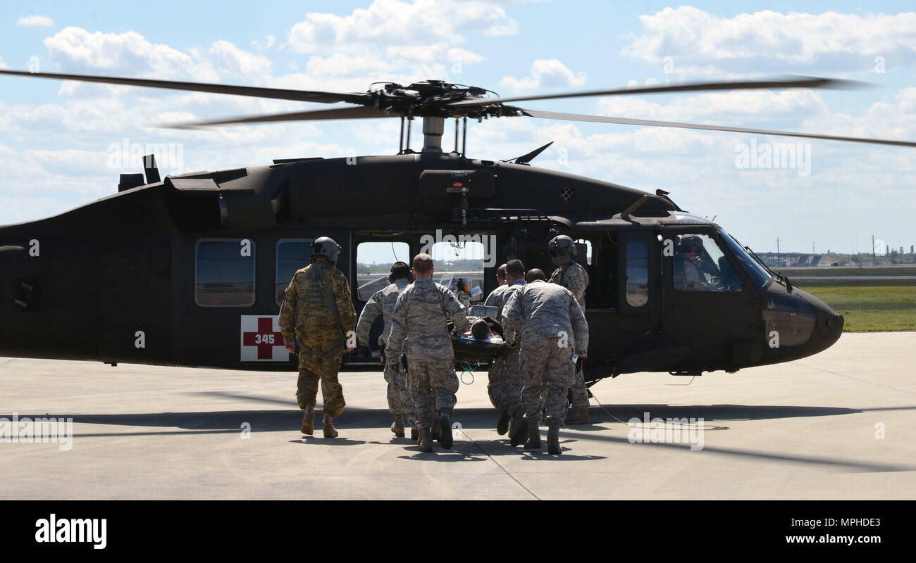 A team of Air Force Reserve rescue medics load a simulated patient connected to an extracorporeal membrane oxygenation machine onto an Army National Guard UH-60 Black Hawk helicopter March 4, 2017 at Patrick Air Force Base, Florida, as part of the 5th annual MEDBEACH joint medical response exercise. More than 250 military medics from 12 units across the country participated in this year's exercise. (U.S. Air Force photo/Capt. Leslie Forshaw) Stock Photo