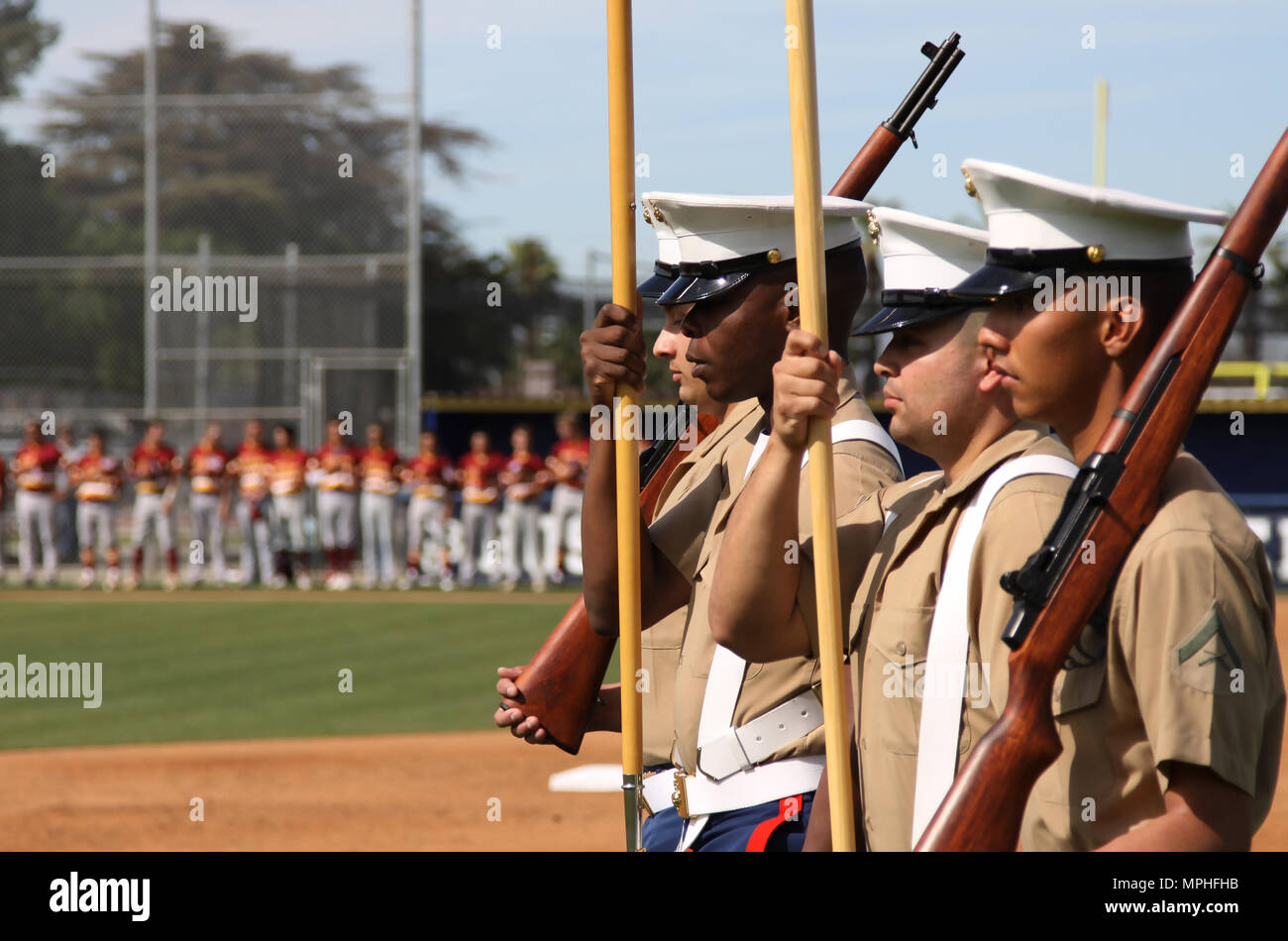 Left to right, Marine Corps Recruiters Sgt. Berrian Macon, Sgt. Victor Romualdo and LCpl. Ulixes Hernandez, present colors during a during a varsity baseball game at St. John Bosco High School, Bellflower, Calif., March 14, 2017. Stock Photo