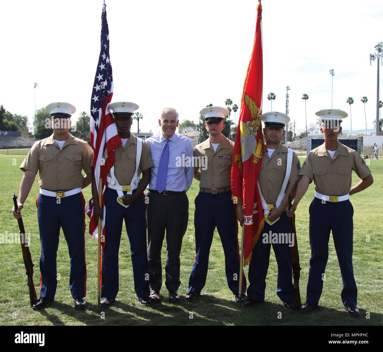 Left to right, Marine Corps Recruiters Sgt. Elijah Gable, Sgt. Derrick Berrian, Mr. Dennis Mulhaupt, president of St. John Bosco High School, SSgt. Phillip Page, Sgt. Victor Romualdo and LCpl. Ulixes Hernandez, pose during a varsity baseball game at St. John Bosco High School, Bellflower, Calif., March 14, 2017. Coming from Recruiting Substation Lakewood, the recruiters were the official color guard for the game. Stock Photo