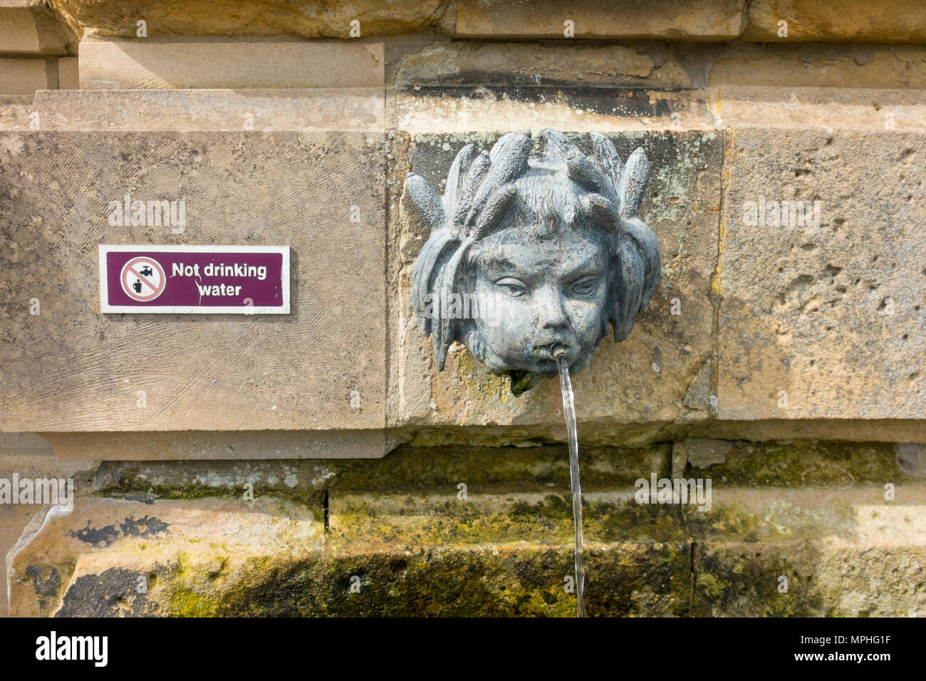 A classic ornamental drinking fountain in the walled garden at Castle Howard with a 'Not Drinking Water' sign Stock Photo