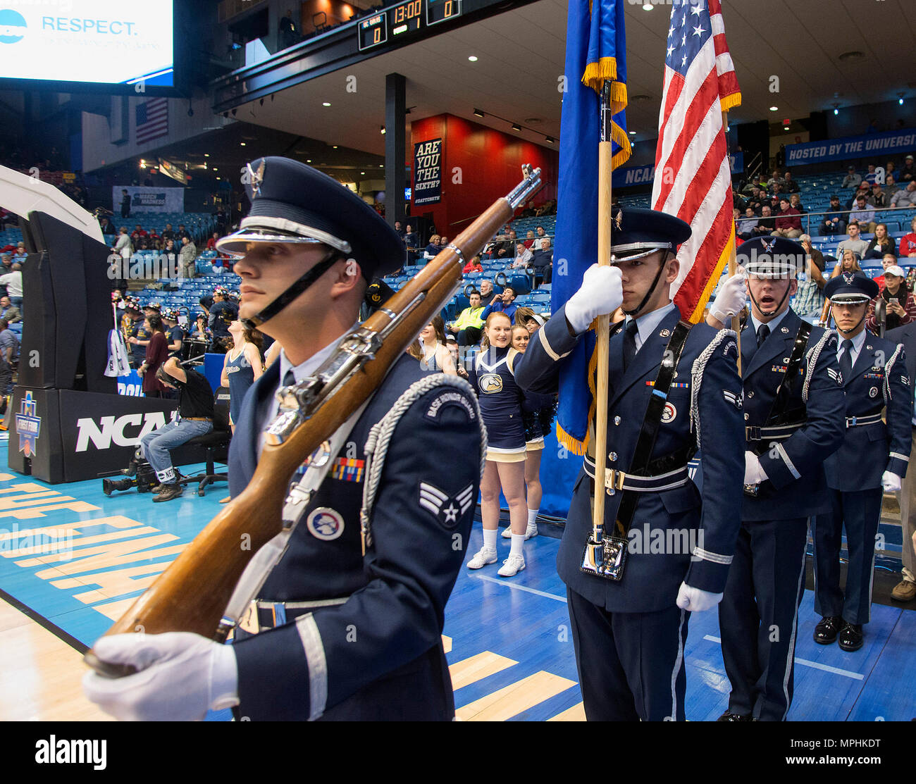 Senior Airman Nicholas Cicone, Wright-Patterson Air Force Base Honor Guard member, gives the command to march as the honor guard enters the court prior to the NCAA First Four game between the University of California Davis and North Carolina Central University in the University of Dayton Arena, March 15, 2017. Airmen from Wright-Patterson Air Force Base took part in the pregame ceremonies including the unfurling of a large American flag and new Airman joined the Air Force through the delayed entry program by taking the oath of enlistment during halftime. (U.S. Air Force photo by R.J. Oriez) Stock Photo