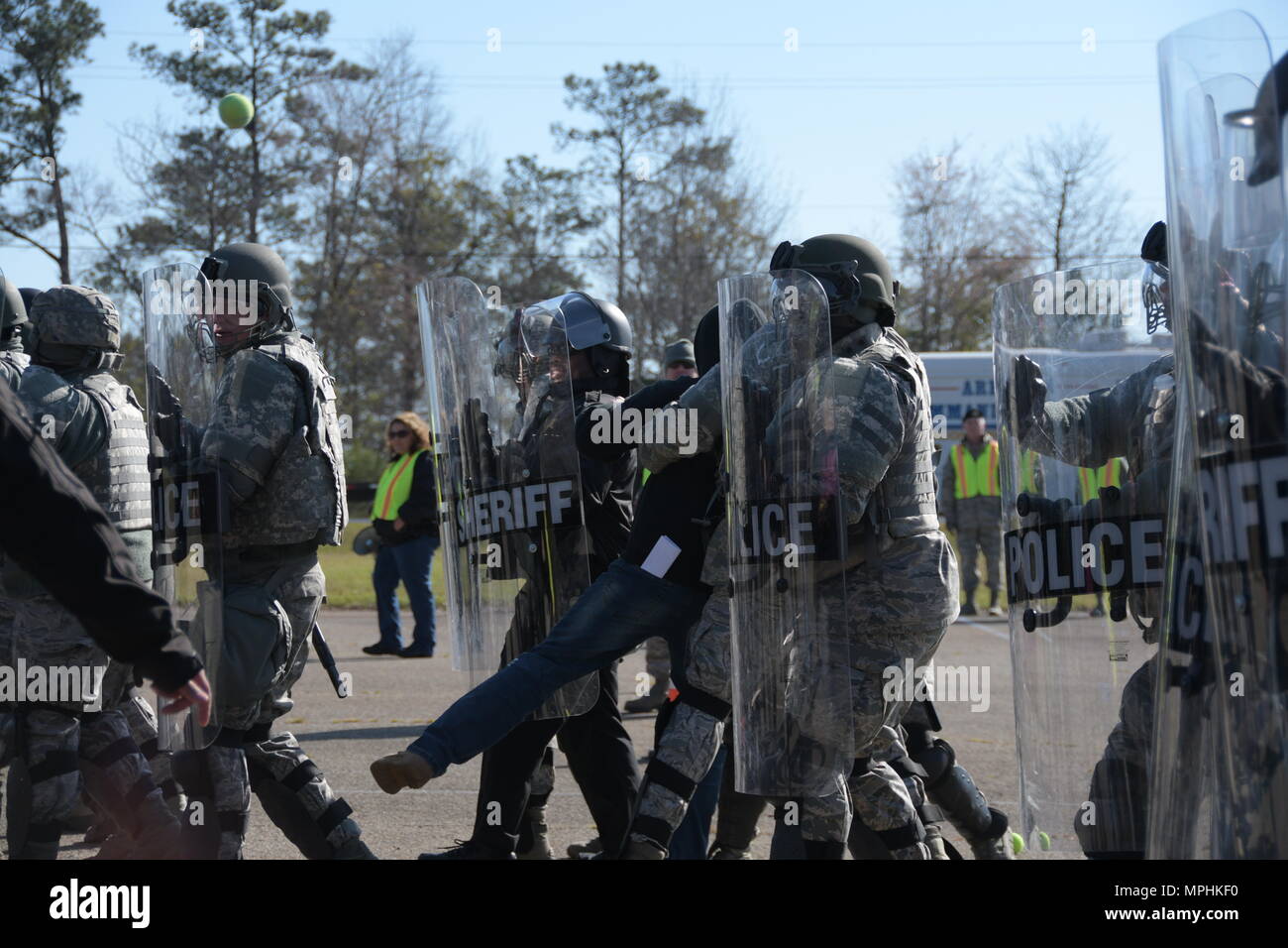 U.S. Air Force security forces Airmen from the 116th Air Control Wing and the 165th Airlift Wing, Georgia Air National Guard, along with officers from Macon-Bibb County Sheriff’s Office, rescue an acting objector from a simulated riot during Vigilant Guard 2017, a crowd-control exercise, March 15, 2017, Macon, Ga. The Airmen participated in the emergency preparedness exercise Vigilant Guard partnering with Macon-Bibb EMA and other agencies to successfully integrate crowd-control techniques during a hurricane simulation to ensure the safety of citizens during possible natural disasters or catas Stock Photo