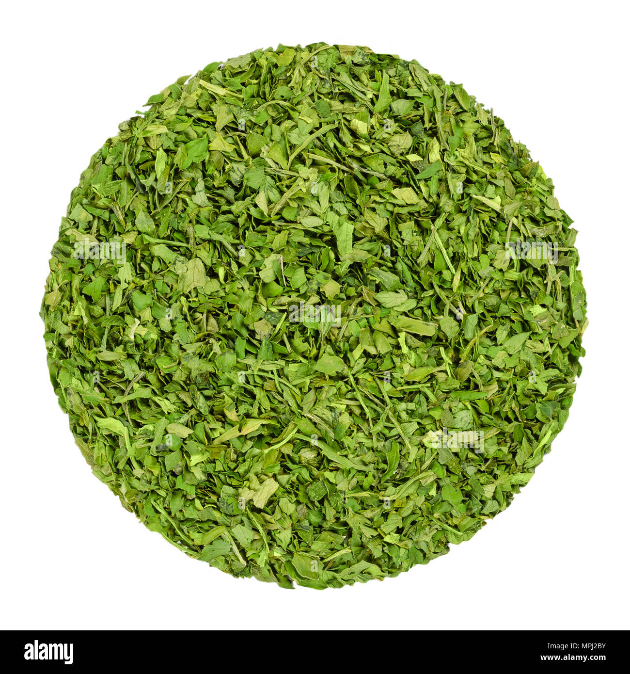 Dried parsley. Herb circle from above, isolated, over white. Disc made of chopped garden parsley, also petersilie. Petroselinum crispum. Green herb. Stock Photo