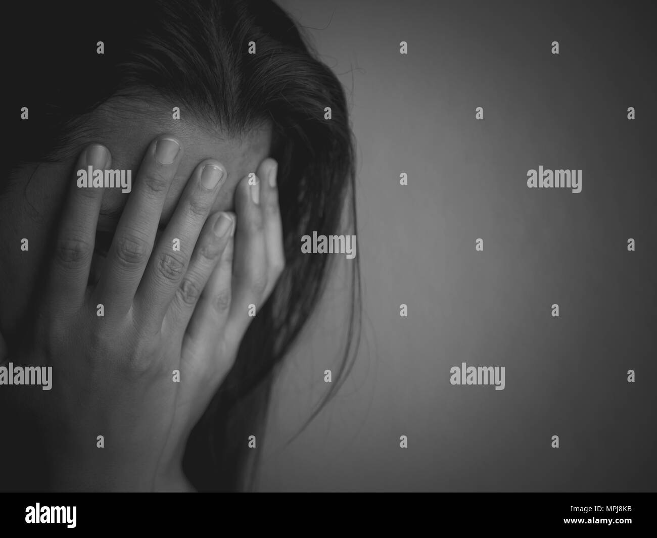 Black and white of Sad woman sitting alone in a empty room. Stock Photo