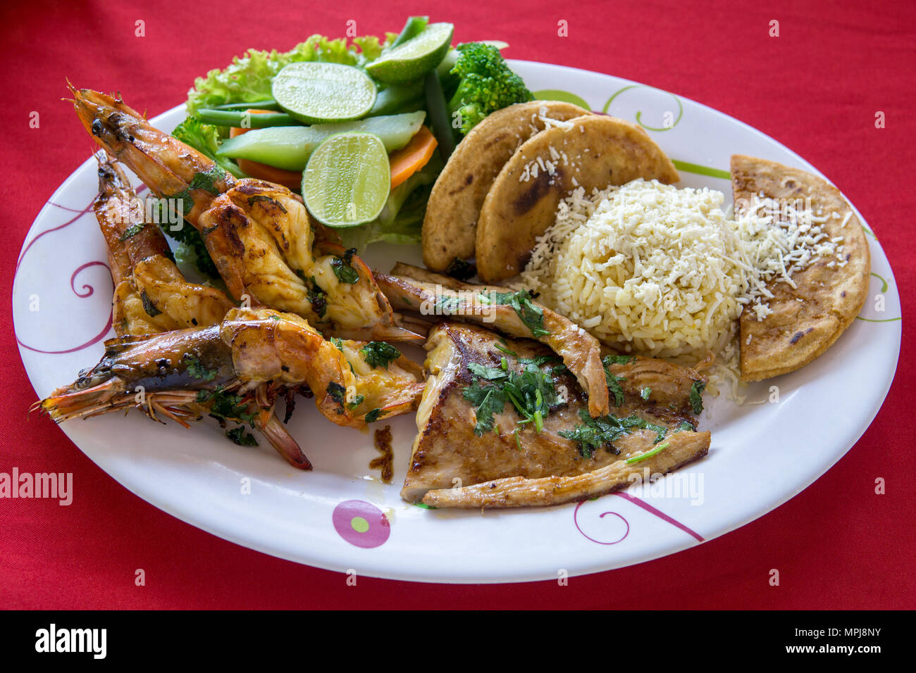 A variety of seafood grill on a large platter. King prawns, crab langoustines and fish with torillas, cheese and lime. Stock Photo