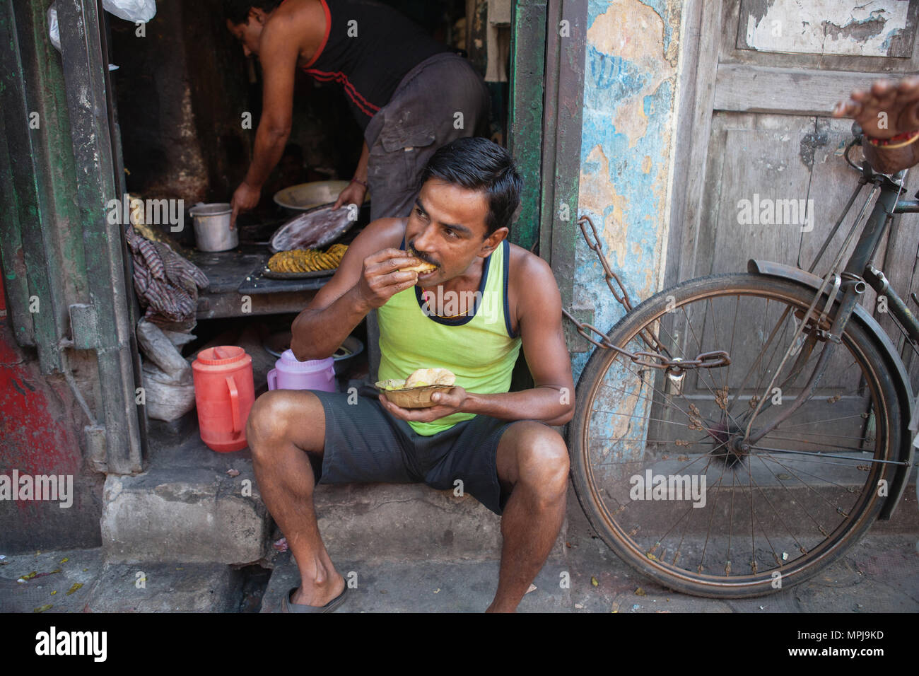 India, West Bengal, Kolkata, A man eating a snack of pani puri and vegetables. Stock Photo