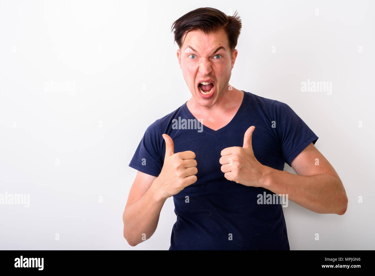 Studio shot of young man looking excited while giving thumbs up  Stock Photo