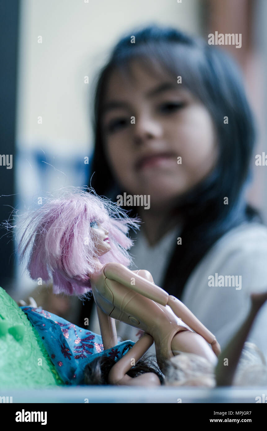 Cute little girl playing with toy doll Stock Photo - Alamy