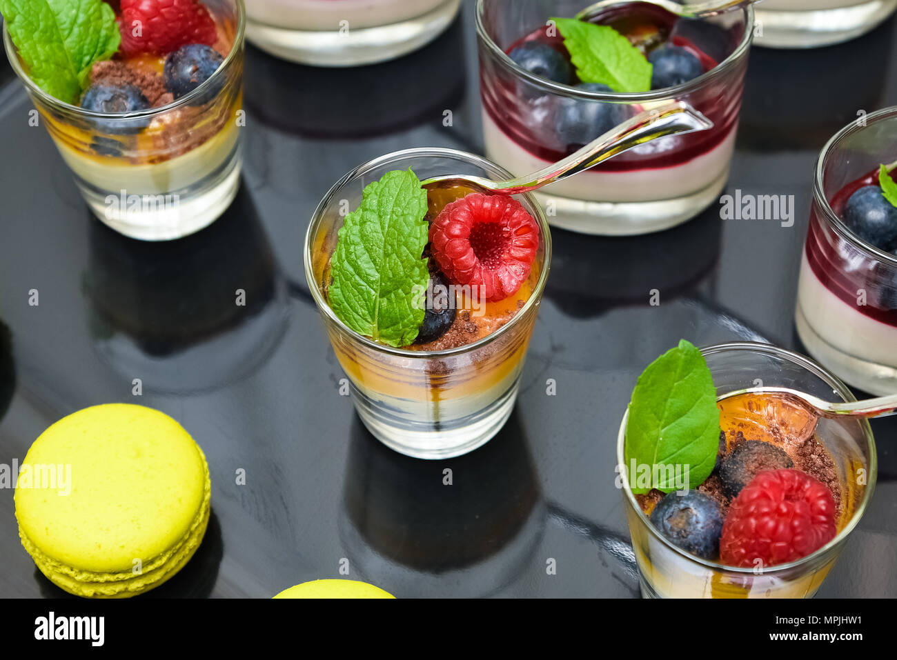 Display of fresh and energizing fruit dessert with forest fruits, mint leafs and colorful cookies. Stock Photo