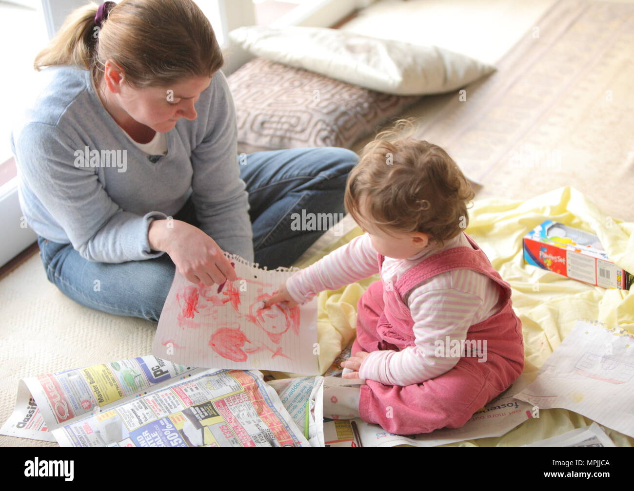 Curious baby toddler girl with mum having fun and painting. Home education painting, age 12 to 18 months February 2010 --- Image by © Paul Cunningham Stock Photo
