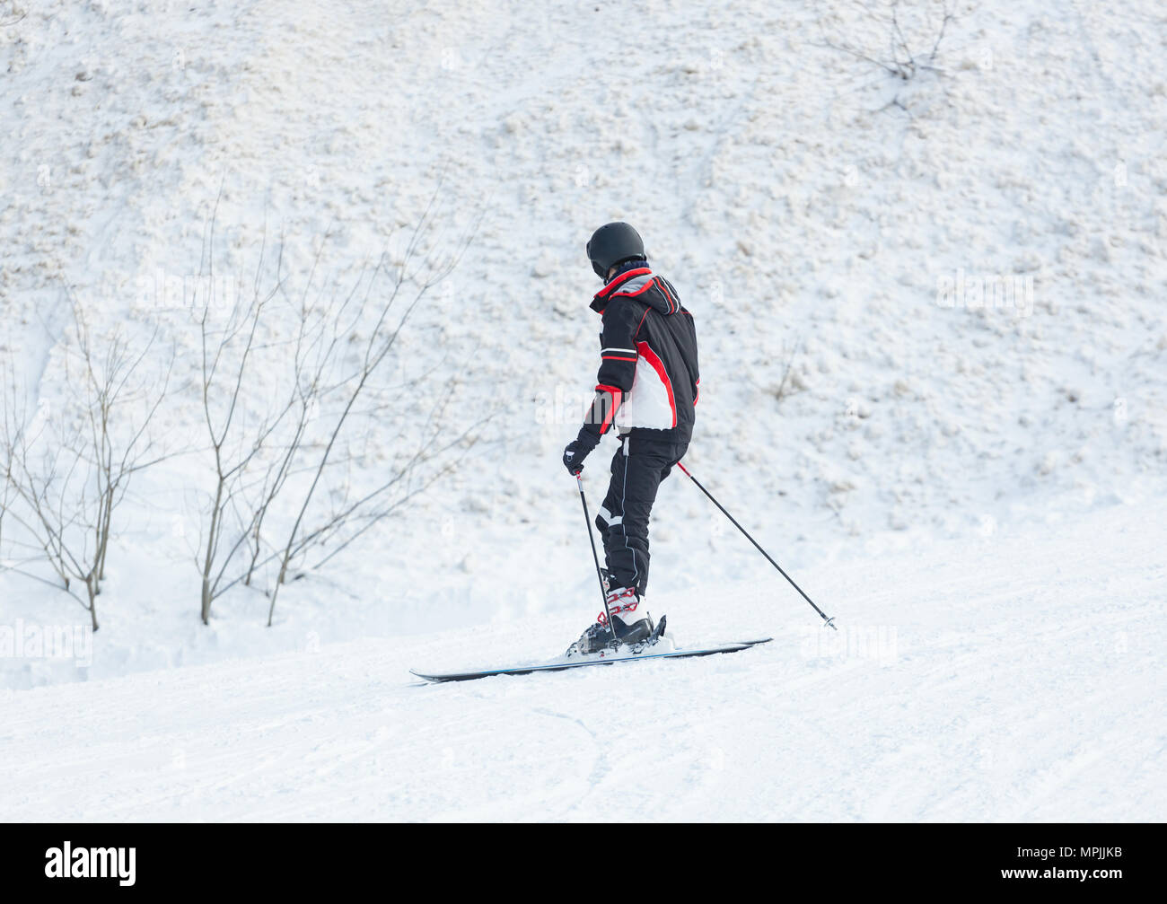 Male skier skiing in fresh snow on ski on a sunny winter day. Stock Photo