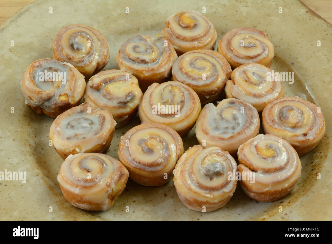 Close up of small cinnamon rolls with icing on ceramic bunch or breakfast party platter Stock Photo