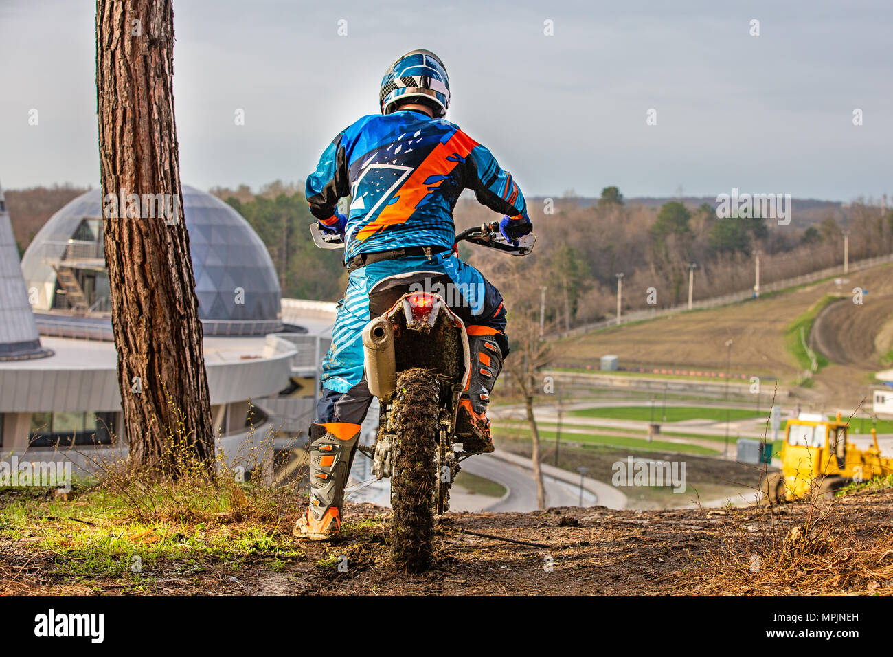 man riding a motocross in a protective suit in the mud Stock Photo - Alamy