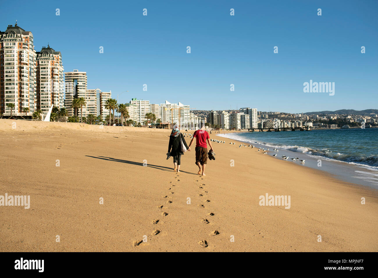 Couple walking on the beach of Viña del Mar, Chile. Stock Photo