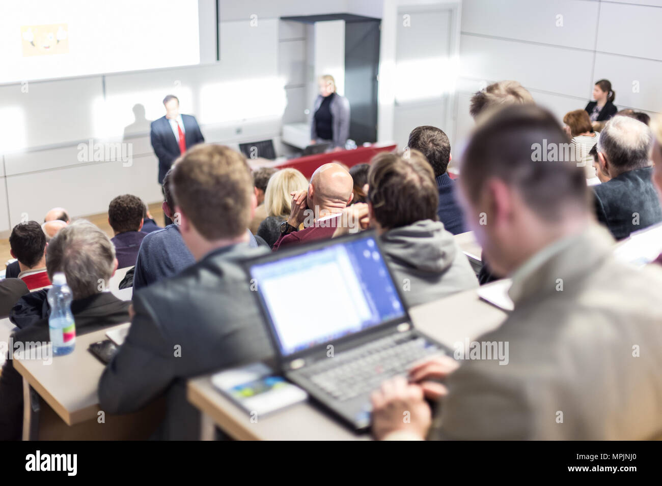 Speaker giving a talk in conference hall at business event. Audience at the conference hall. Business and Entrepreneurship concept. Focus on unrecogni Stock Photo