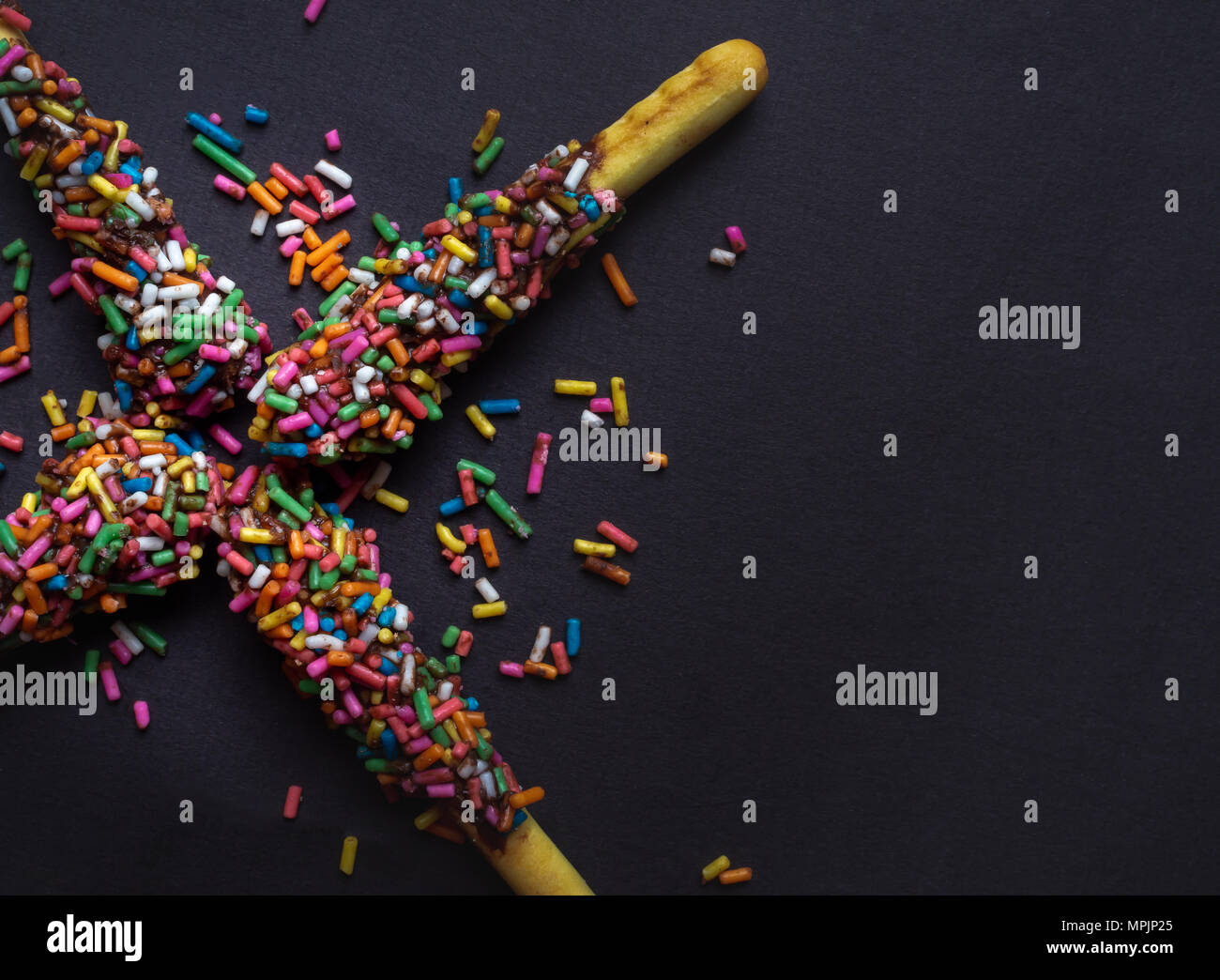 Bread Sticks with Chocolate and Colorful Topping with Space on Black