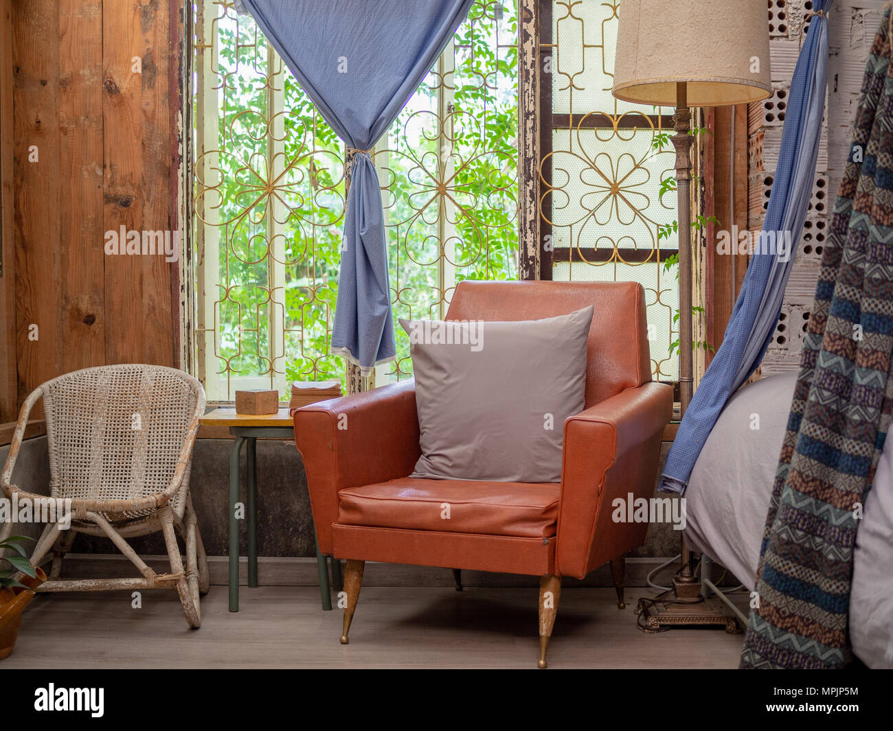 Sunlight from The Window in Living Room In The Morning, Gray Pillow on Retro Light Red Sofa with Floor Lamp, Weaves Chair, Bed and  Curtain, Vintage F Stock Photo