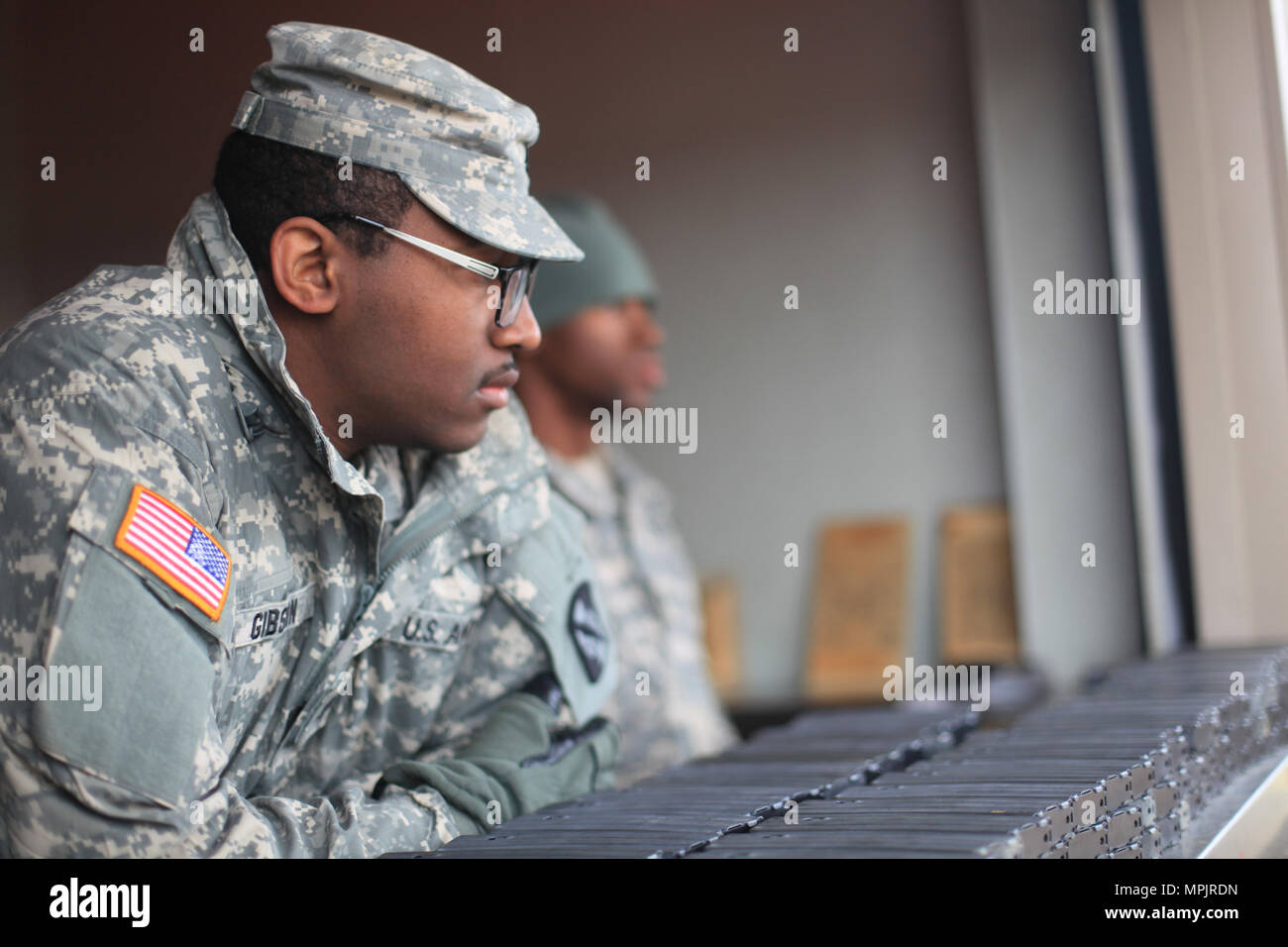 U.S. Army Pfc. Adrian Gibson, Combat Cameraman of the 982nd Combat Camera Company (Airborne), stands ready to issue out ammo for soldiers qualifying their weapons on Fort Jackson, S.C., March 18, 2017. The 982nd Combat Camera Company (Airborne) is one of only two combat camera companies tasked with providing the Office of the Secretary of Defense, Chairman of the Joint Chiefs of Staff, and the military departments with a directed imagery capability in support of operational and planning requirements through the full range of military operations. (U.S. Army photo by Pfc. Keely Key) Stock Photo