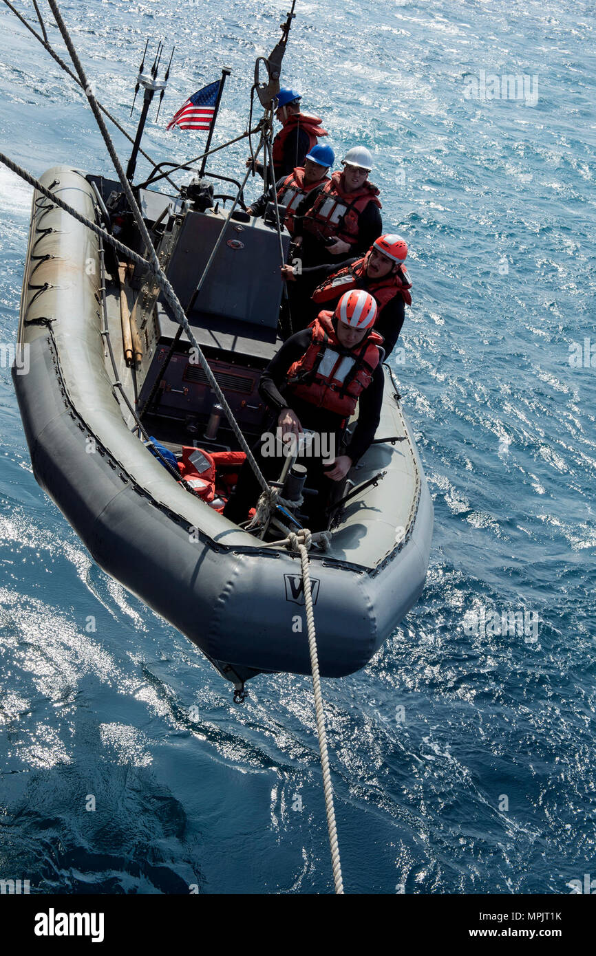Sailors prepare in a rigid hull inflatable boat (RHIB) off the port ...