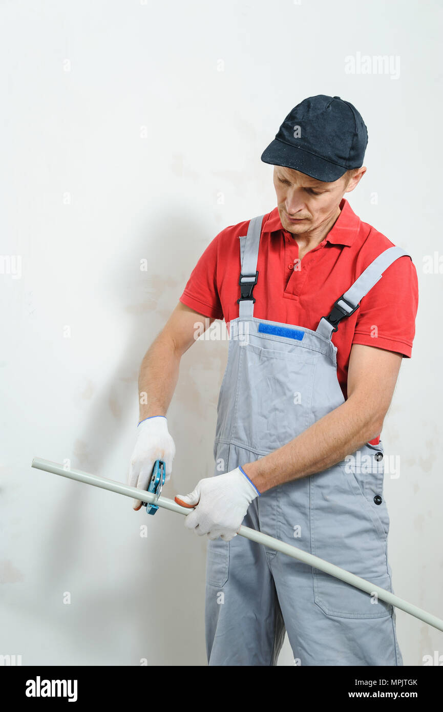 Soldering plastic pipe. Worker cutting pipe scissors Stock Photo Alamy